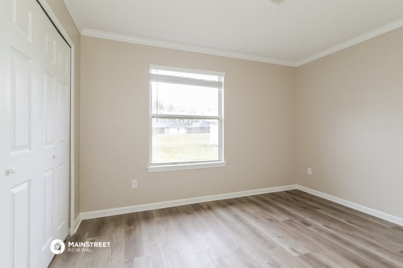 an empty room with wooden floors and a window