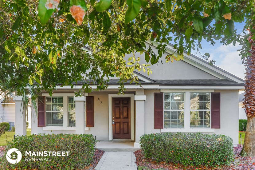 a small white house with a tree in front of it