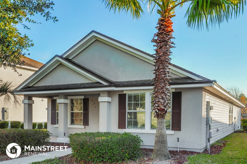 a small white house with a palm tree in front of it