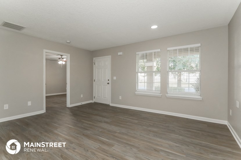 the spacious living room of this manufactured home has a hardwood floor and grey walls