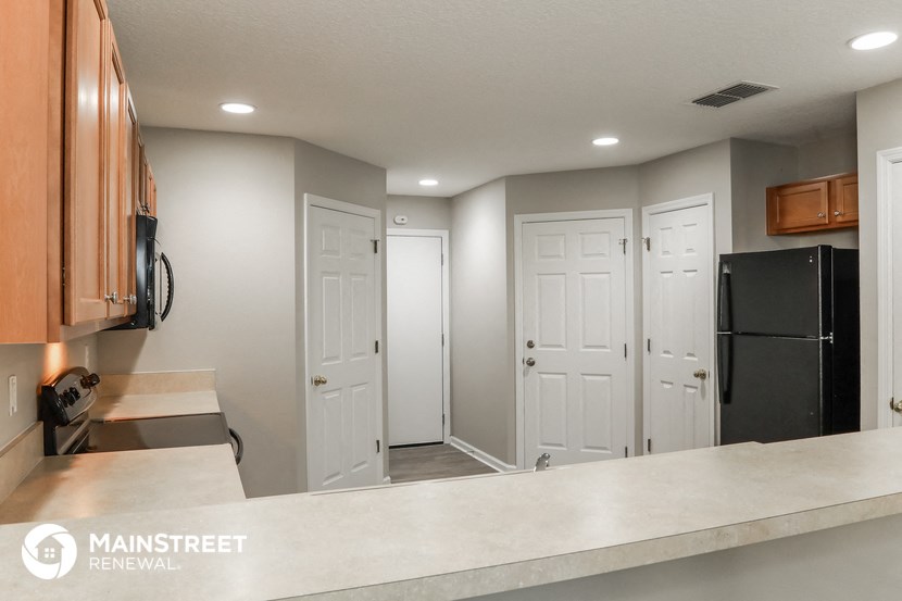 a renovated kitchen with white doors and a counter top