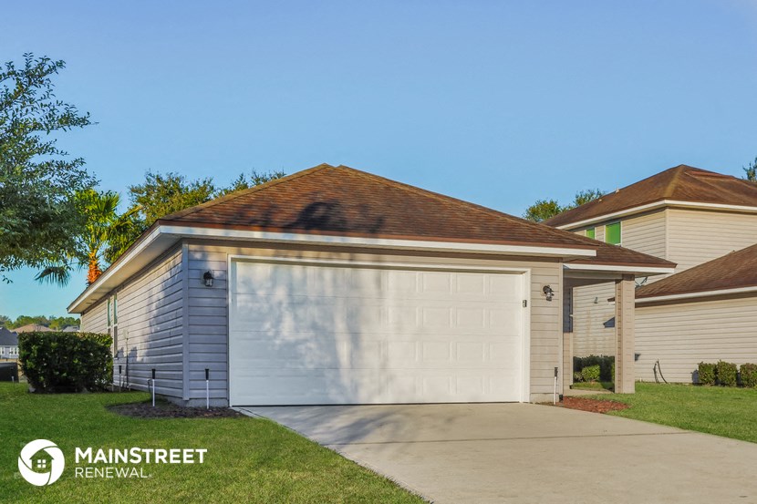 a garage with a white garage door in front of a house