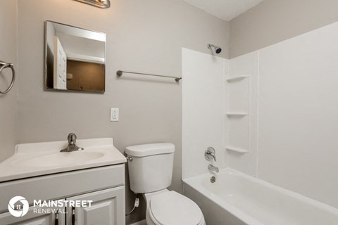 a white bathroom with a white toilet and a tub and a sink