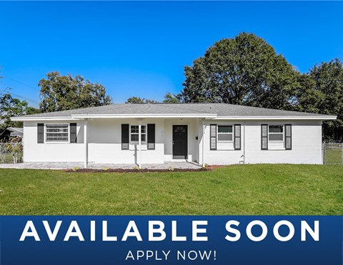 a white house with a lawn and a blue sky