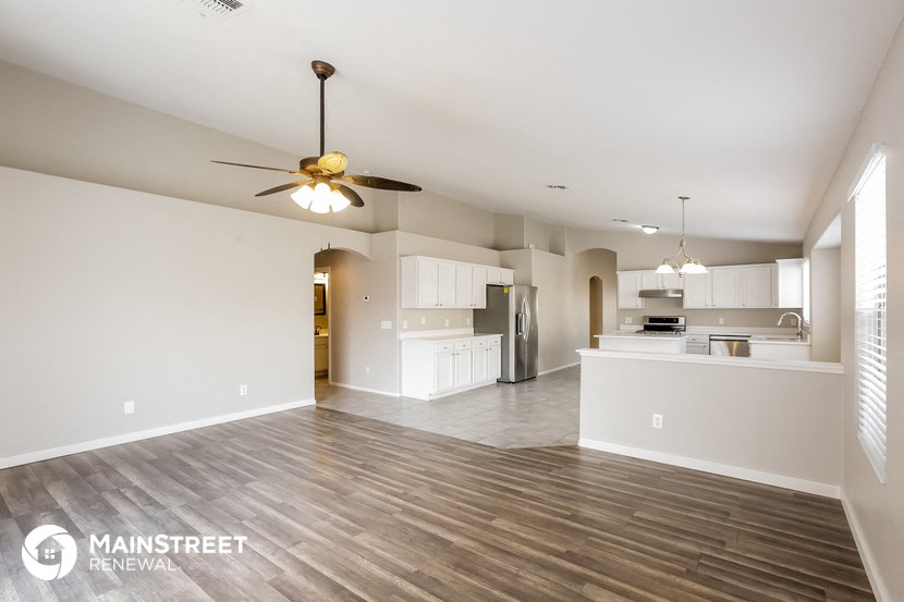 the spacious living room and kitchen of an apartment
