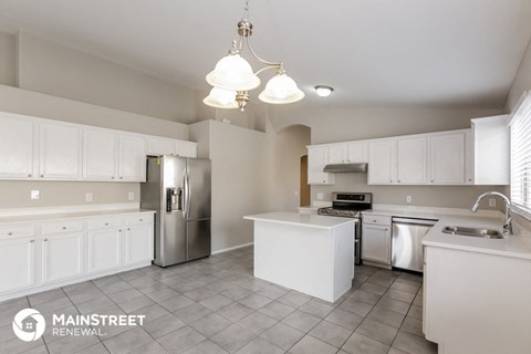 a large kitchen with white cabinets and stainless steel appliances