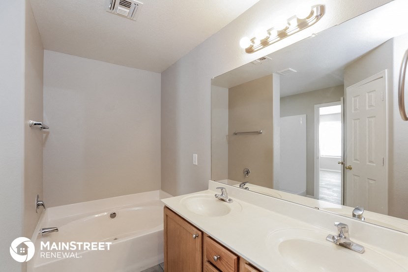 a bathroom with a large mirror and a sink and a tub