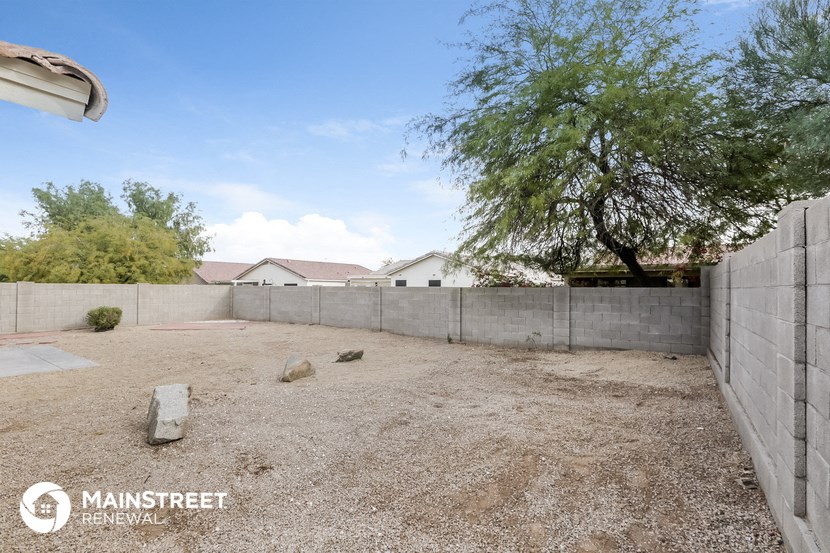 a back yard with a fence and a house in the background