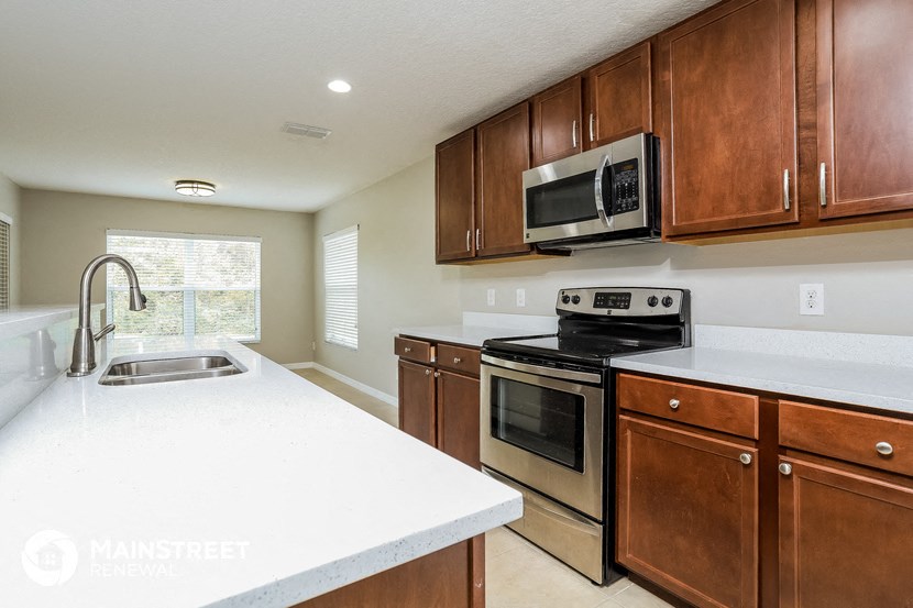 a kitchen with wooden cabinets and a white counter top