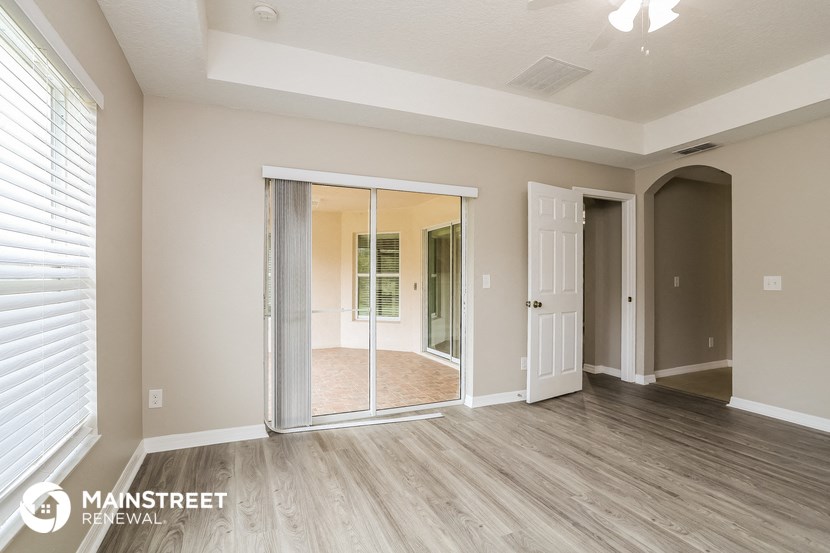 the living room of a new home with a mirrored closet and wood flooring