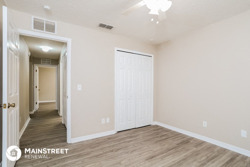the spacious living room and hallway of an apartment