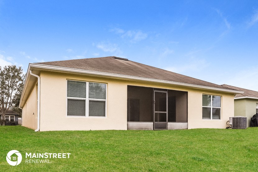 a home with a lawn and a blue sky