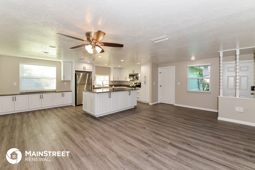 an open kitchen and living room with a ceiling fan