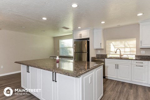 a kitchen with white cabinets and a granite counter top