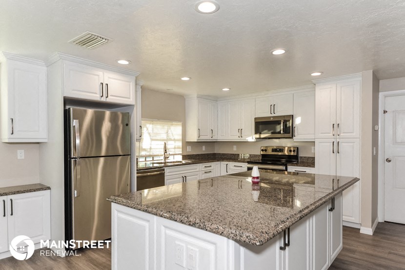 a kitchen with white cabinets and a granite counter top
