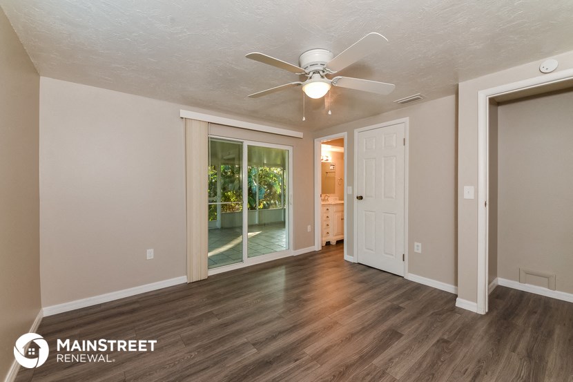 the living room of an empty house with a ceiling fan