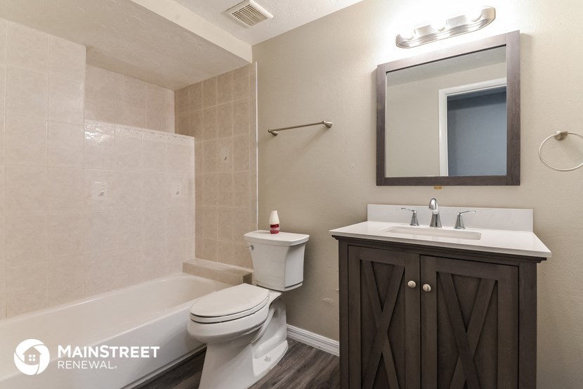 a bathroom with a toilet sink and tub and a mirror