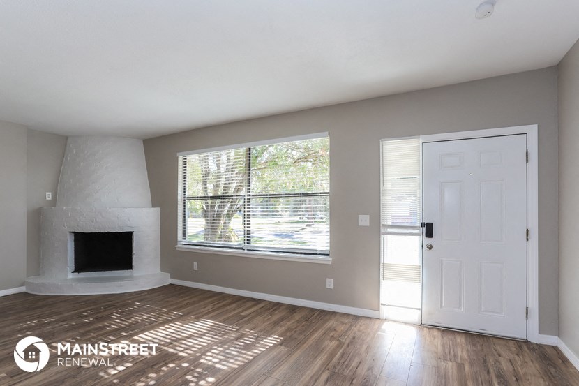 the living room has a fireplace and a large window