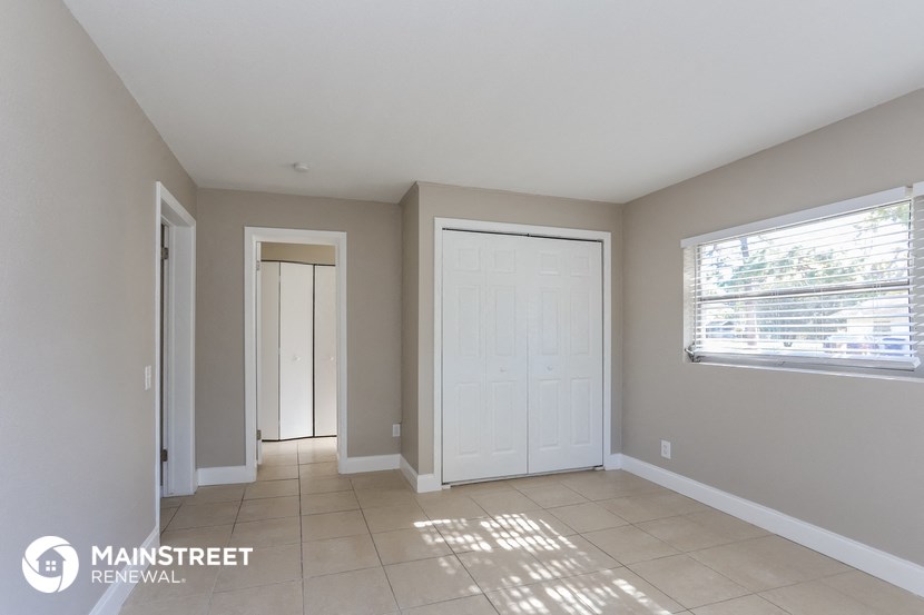 an empty room with two doors and a window