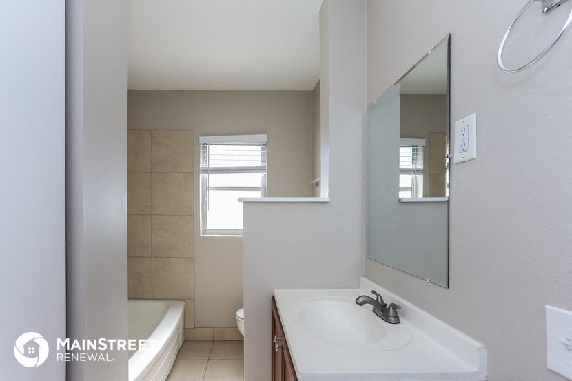 a bathroom with a sink and a tub and a mirror