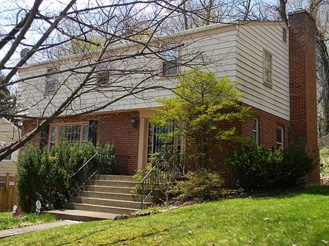 A house with a red brick exterior and a white siding.