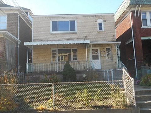 a yellow house with a fence in front of it
