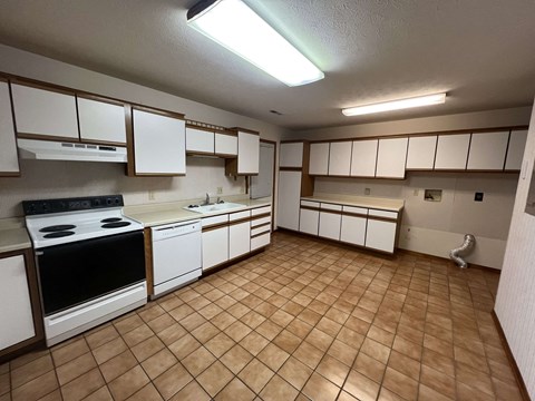 A kitchen with white cabinets and a black stove top oven.