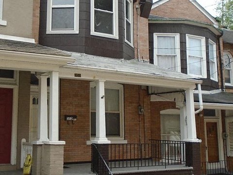 A house with a red door and a black railing.