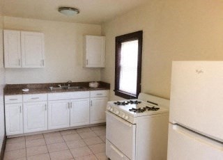 a white kitchen with a stove and a refrigerator