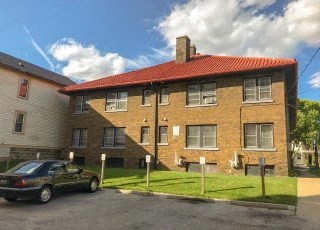 an apartment building with a car parked in front of it