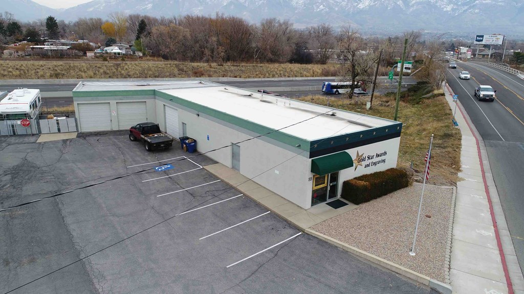 A parking lot with a building and a mountain in the background.