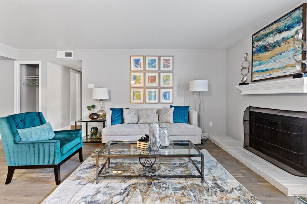 a living room with a couch and a glass coffee table and a fireplace