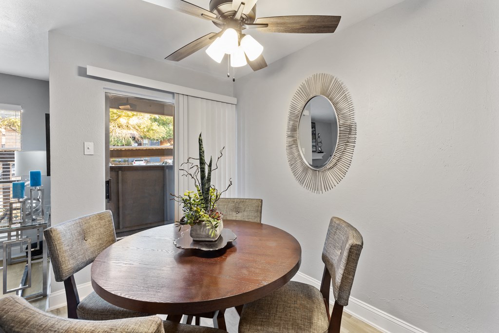 a dining room with a table and chairs and a ceiling fan