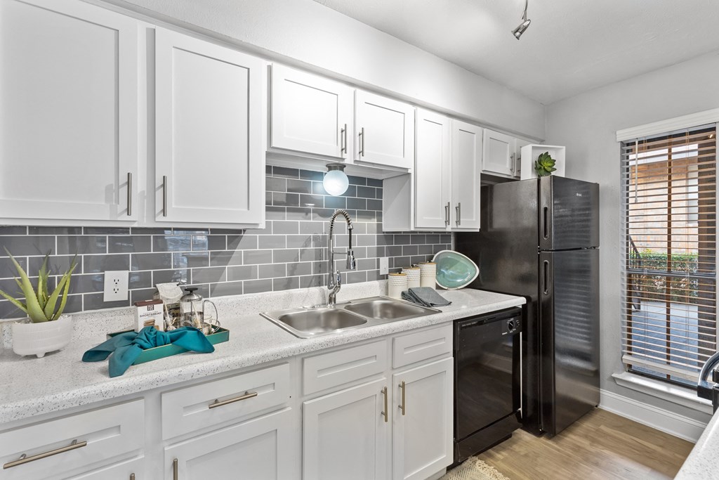 a kitchen with white cabinets and a sink and a refrigerator