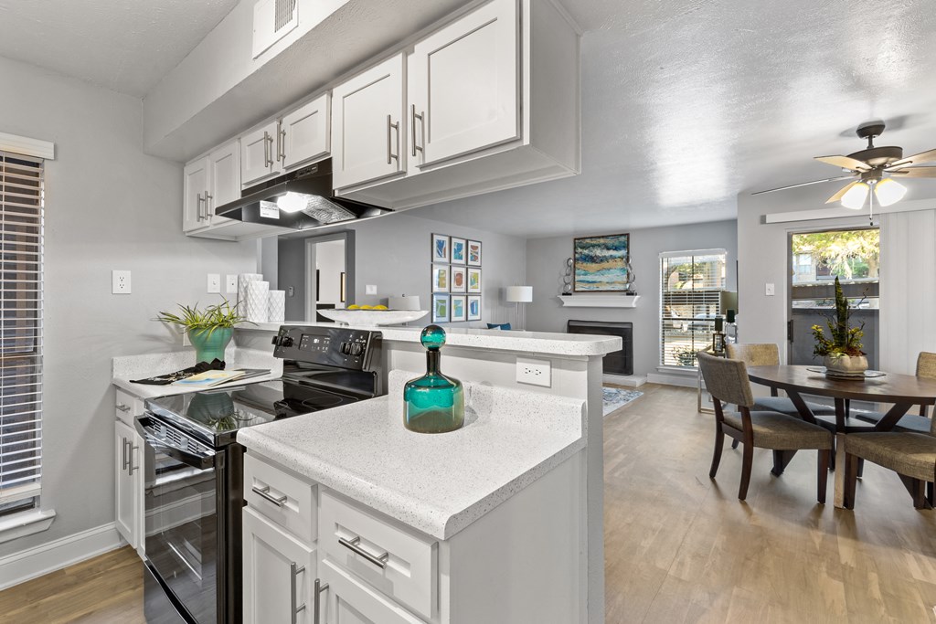 an open kitchen and dining room with white cabinets and white counter tops