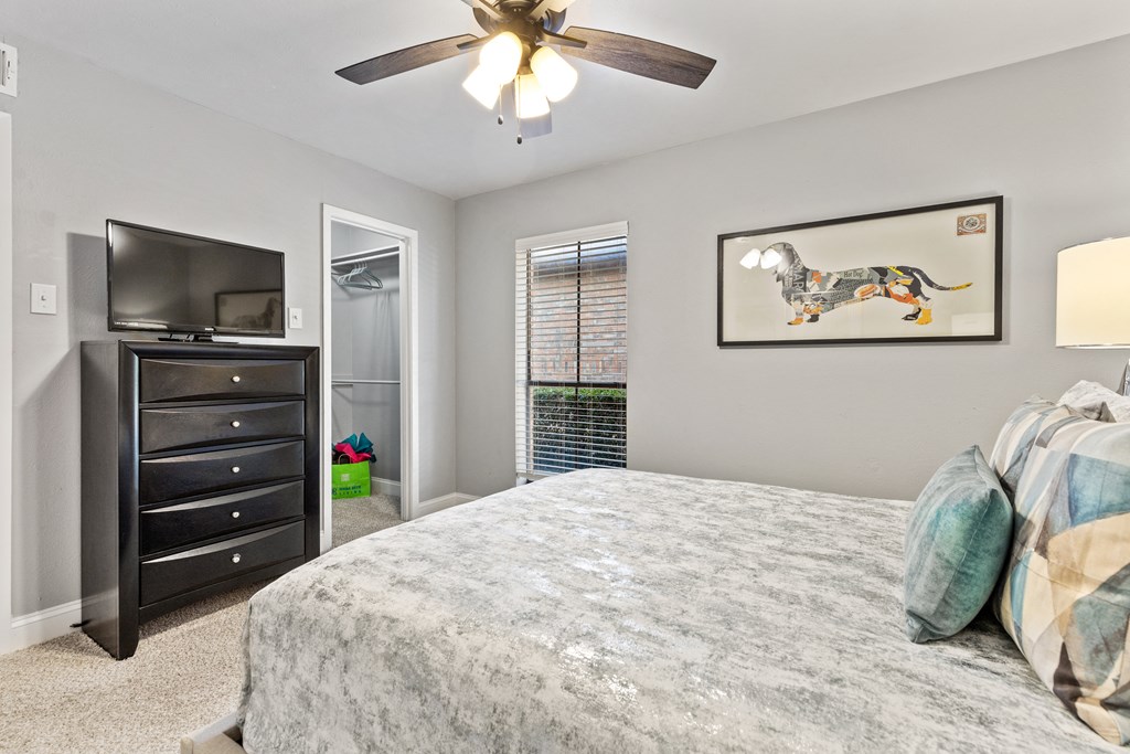 a bedroom with a large bed and a ceiling fan