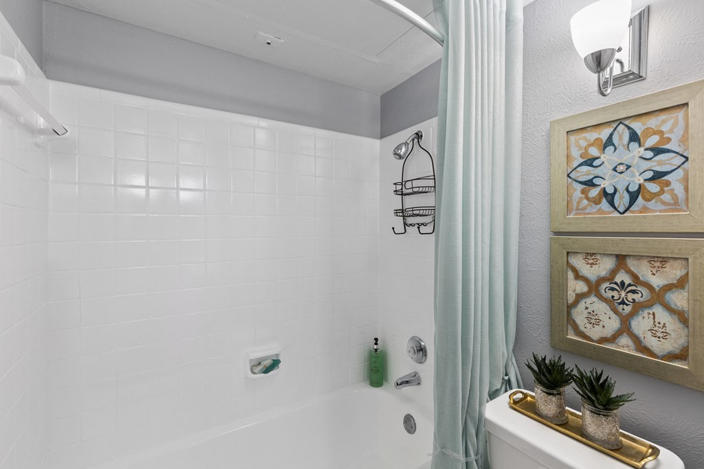 a white bathroom with a shower and a toilet and a sink