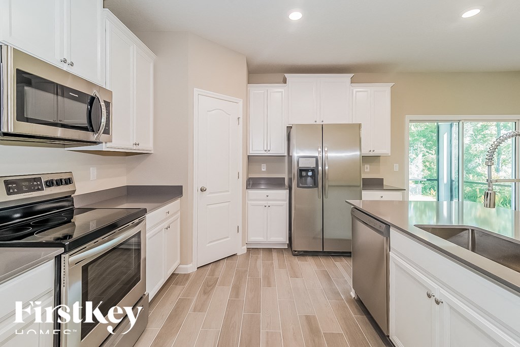 a kitchen with stainless steel appliances and white cabinets