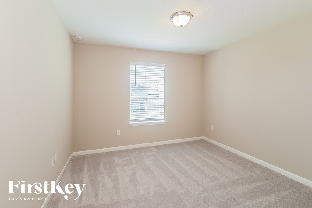 a bedroom with a carpeted floor and a window