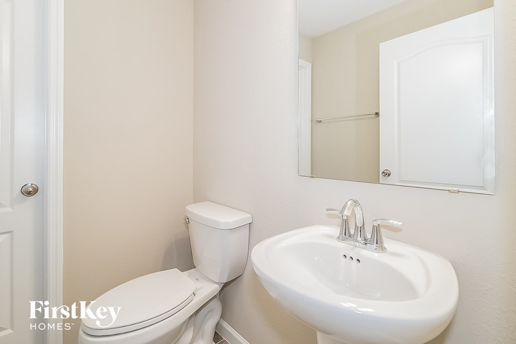 a bathroom with a sink toilet and a mirror