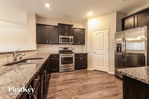 A kitchen with wooden floors and a granite counter top.