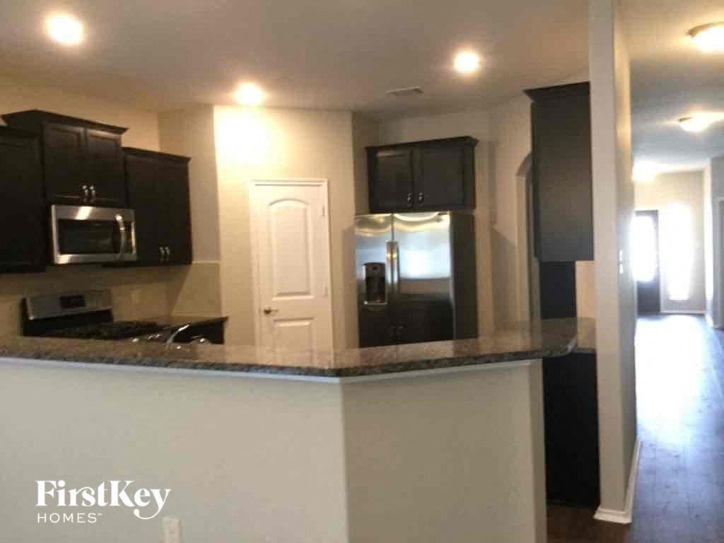 A kitchen with black cabinets and a white counter.