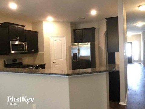 A kitchen with black cabinets and a white counter.