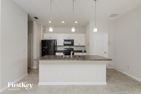 A kitchen with a granite countertop and a refrigerator.
