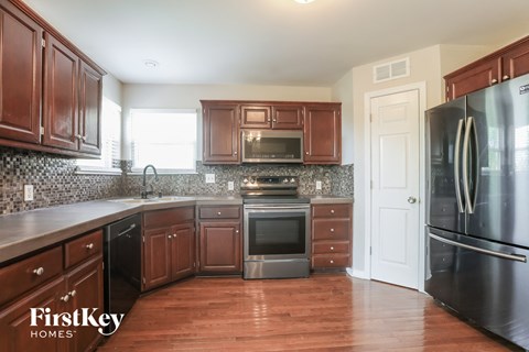 a kitchen with dark wood cabinets and stainless steel appliances