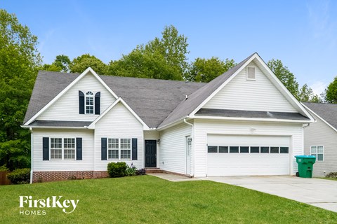 a white house with green shutters and a lawn