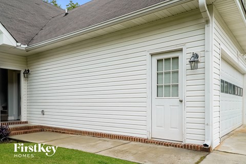 the outside of a white house with a white door