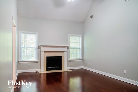 a living room with a fireplace and wooden floors