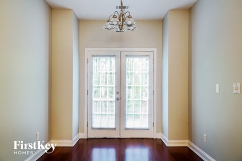 a empty living room with a chandelier and doors