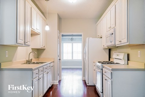 a kitchen with white cabinets and white appliances and a white refrigerator